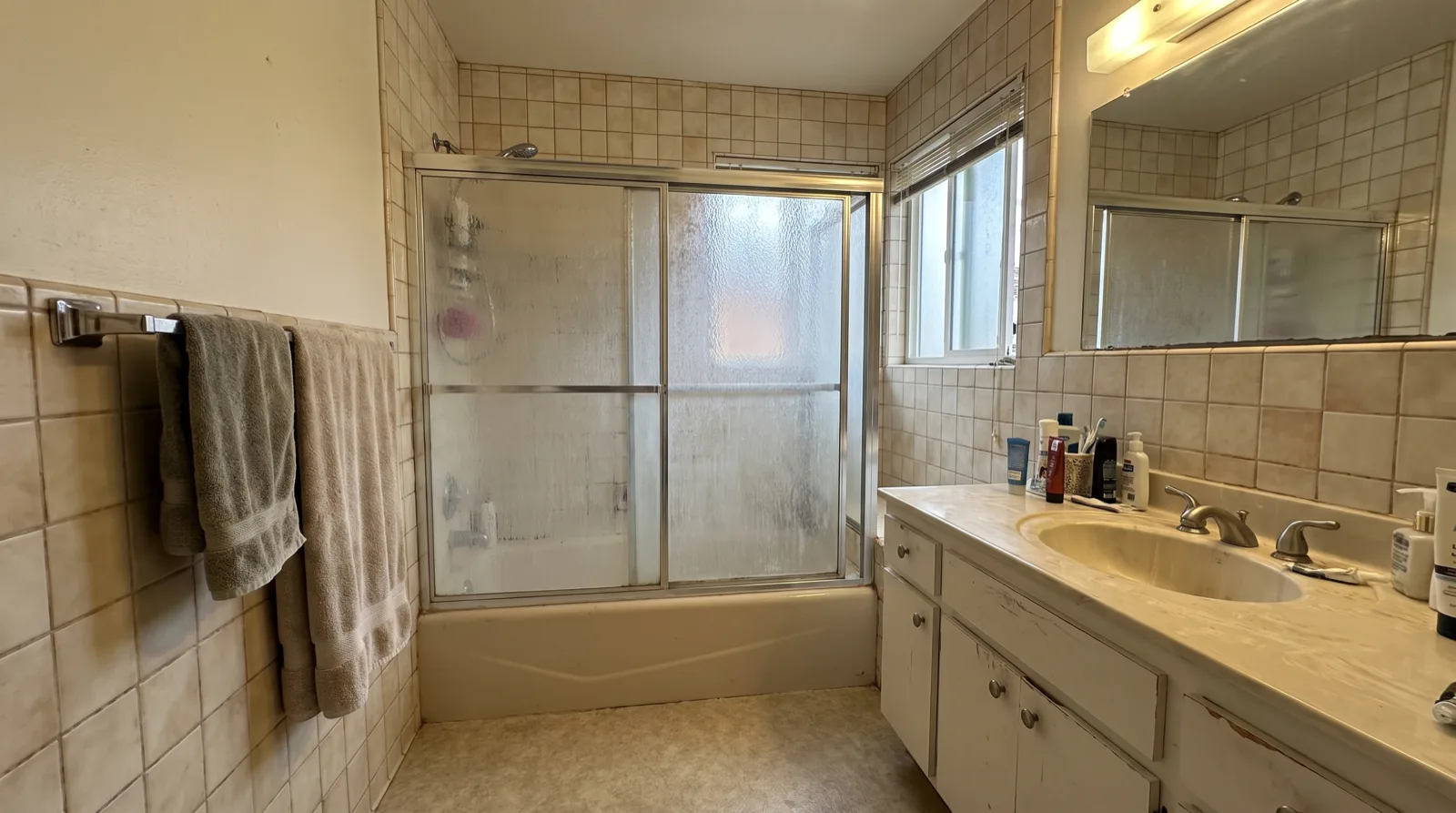 A dated Rochester bathroom with an old tub-and-shower combo before an ROC remodel
